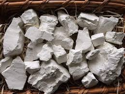 Raw kaolin clay lumps compared with processed kaolin powder grades
